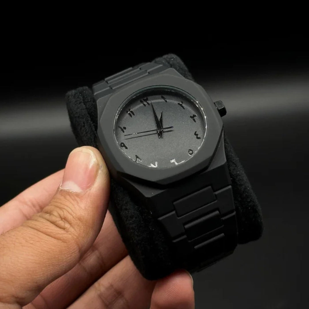 Black aura wristwatch held in a hand against a dark background