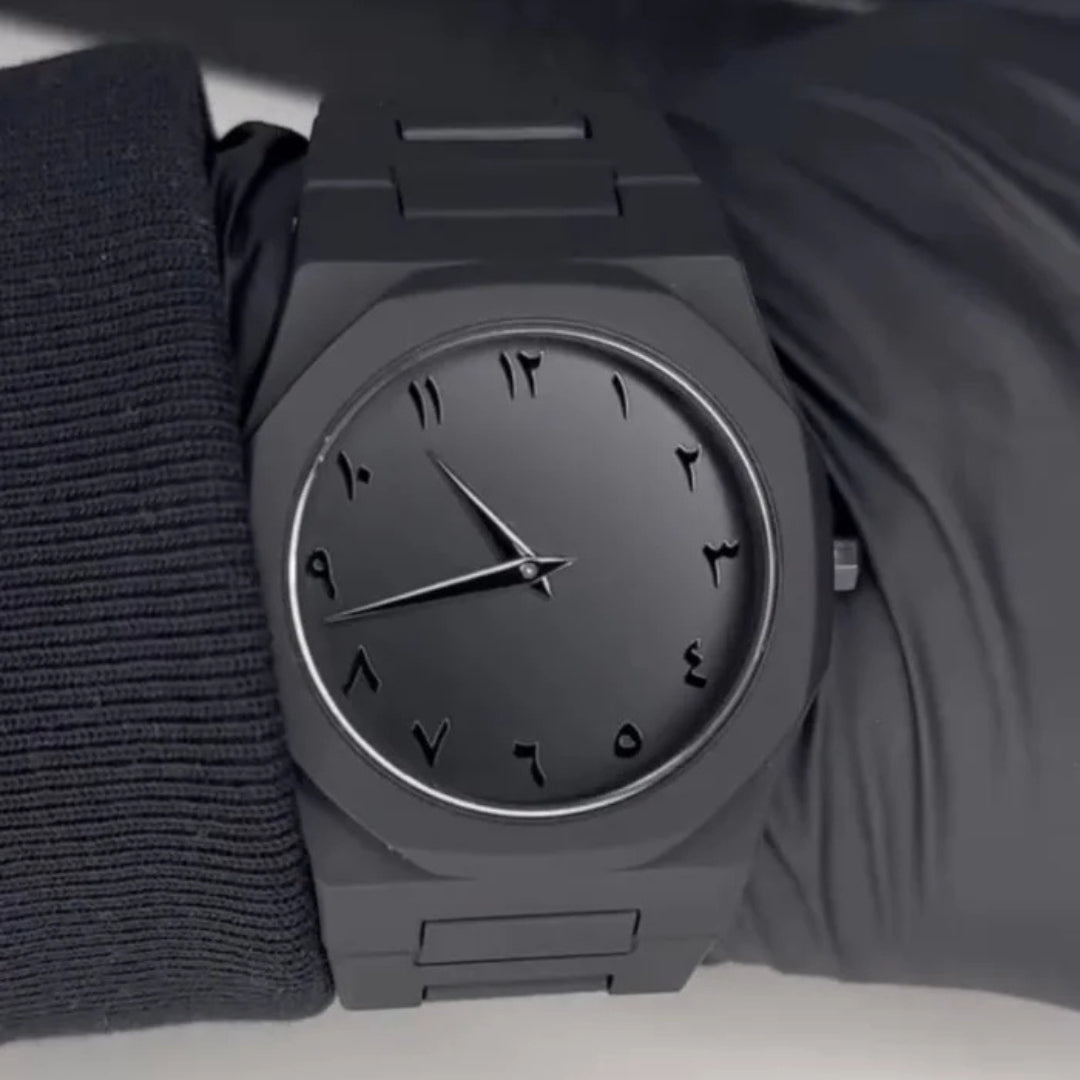 Black aura wristwatch with a textured strap on a plain background